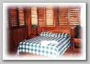 Bedroom with wooden shutters at Malpais Surf Camp